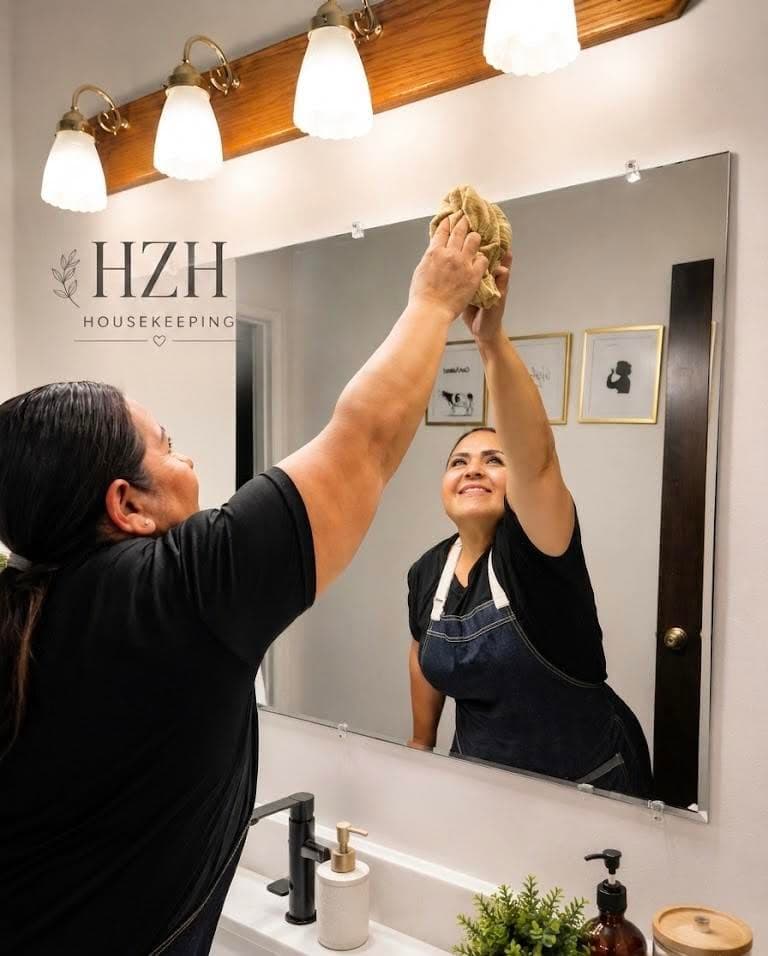 HZH Housekeeping cleaning a bathroom mirror